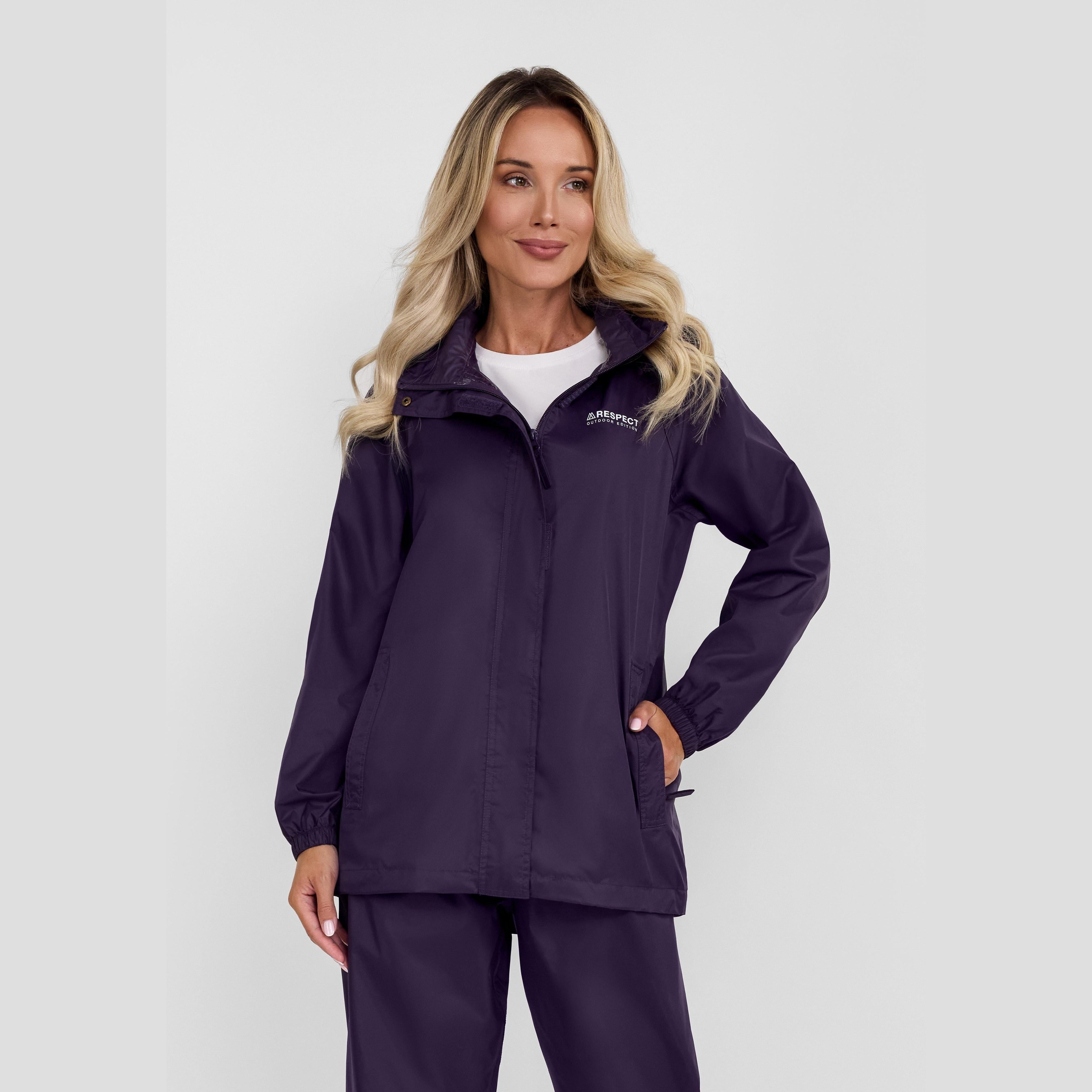 Woman wearing purple packaway waterproof jacket with hood up, shown against neutral background in full length view