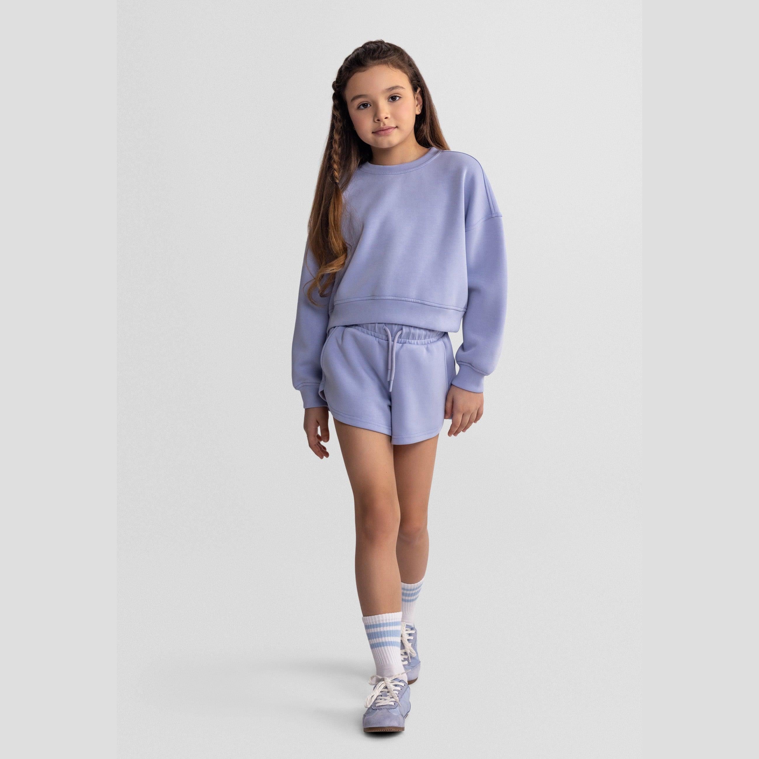 Back view of lavender sweatshirt showing relaxed fit and ribbed hem detail on white background