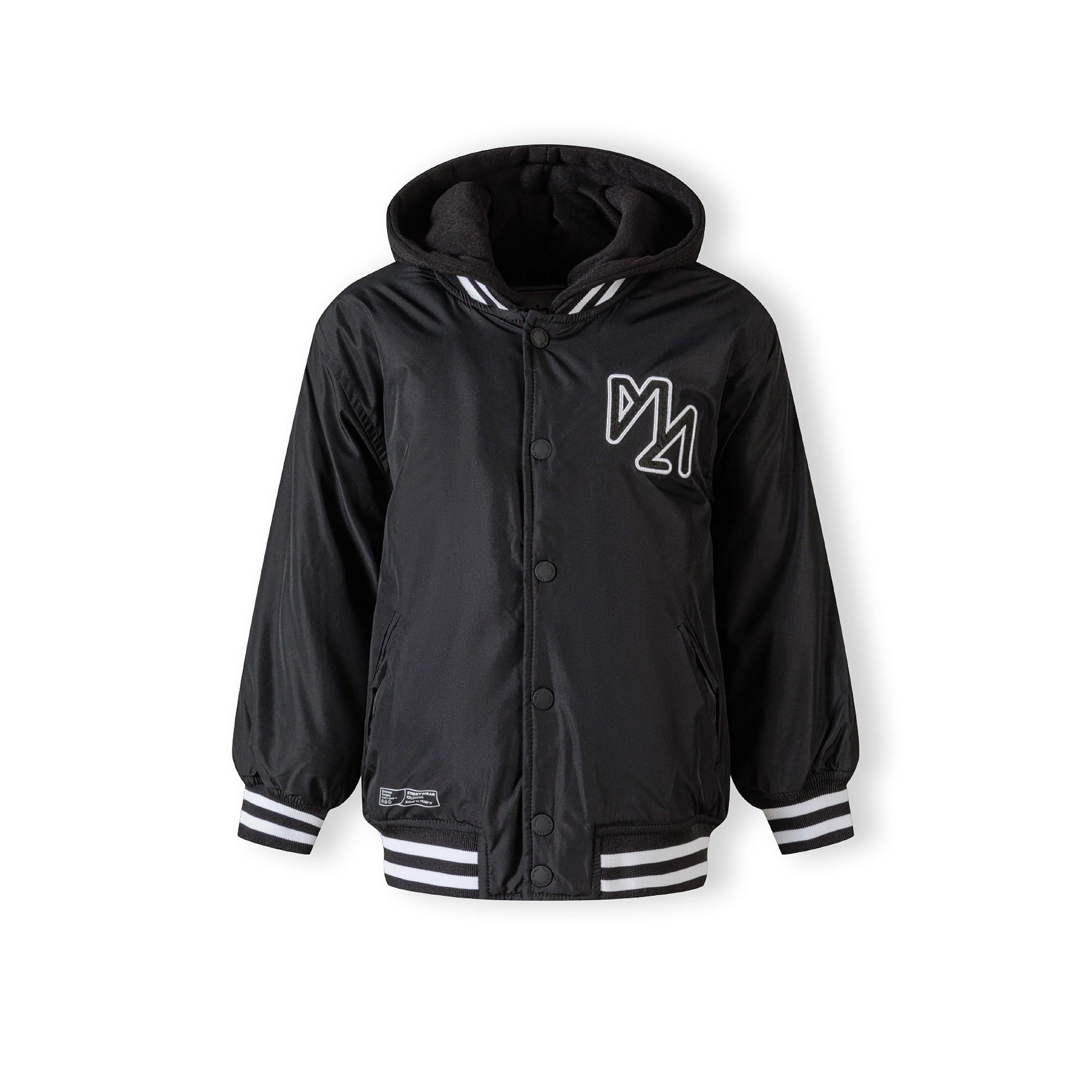 Close-up detail of black baseball jacket showing white embroidered logo and snap button closure with striped ribbed trim