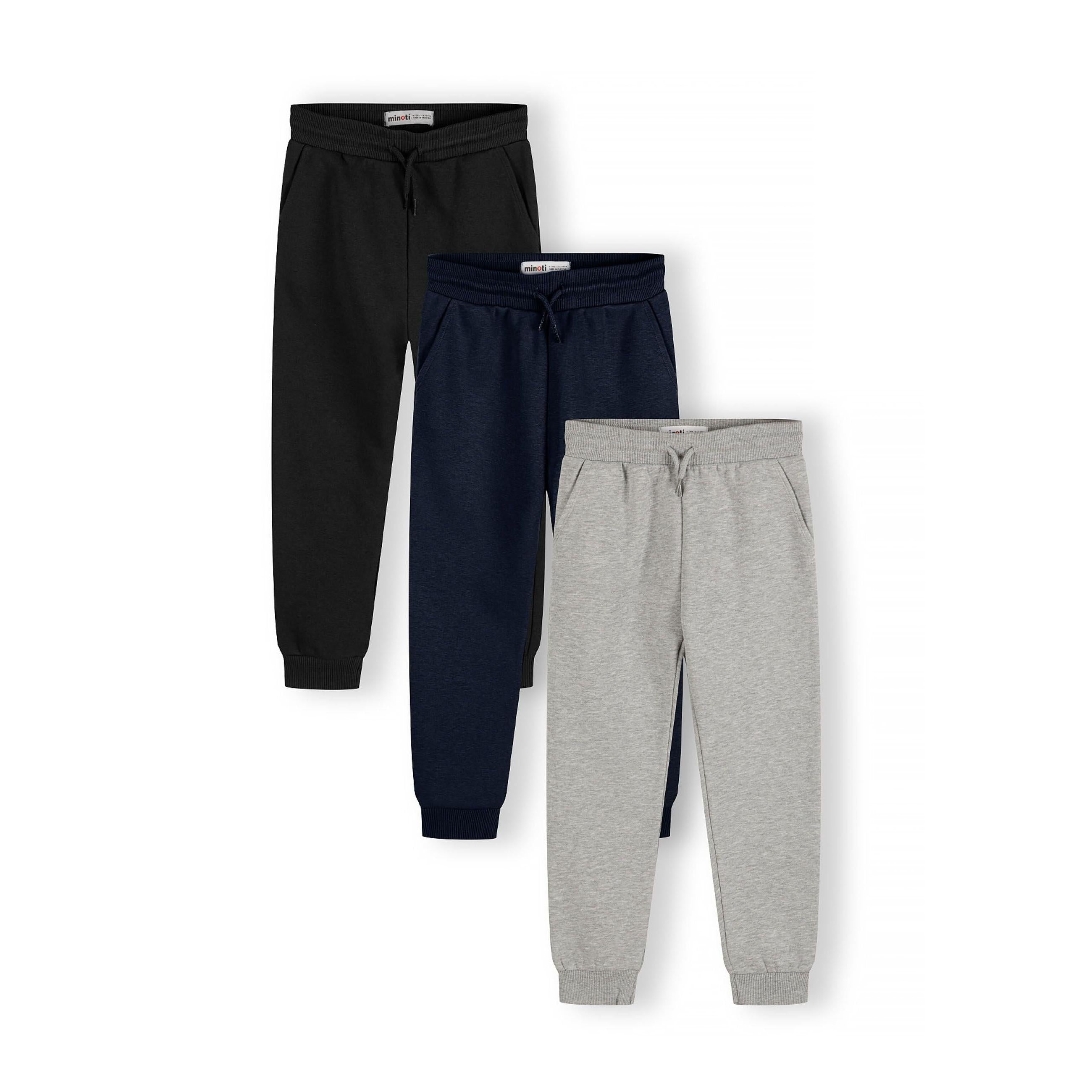 Three Minoti joggers laid flat showing navy, black and grey colours with ribbed cuffs and drawcord waistbands on white background
