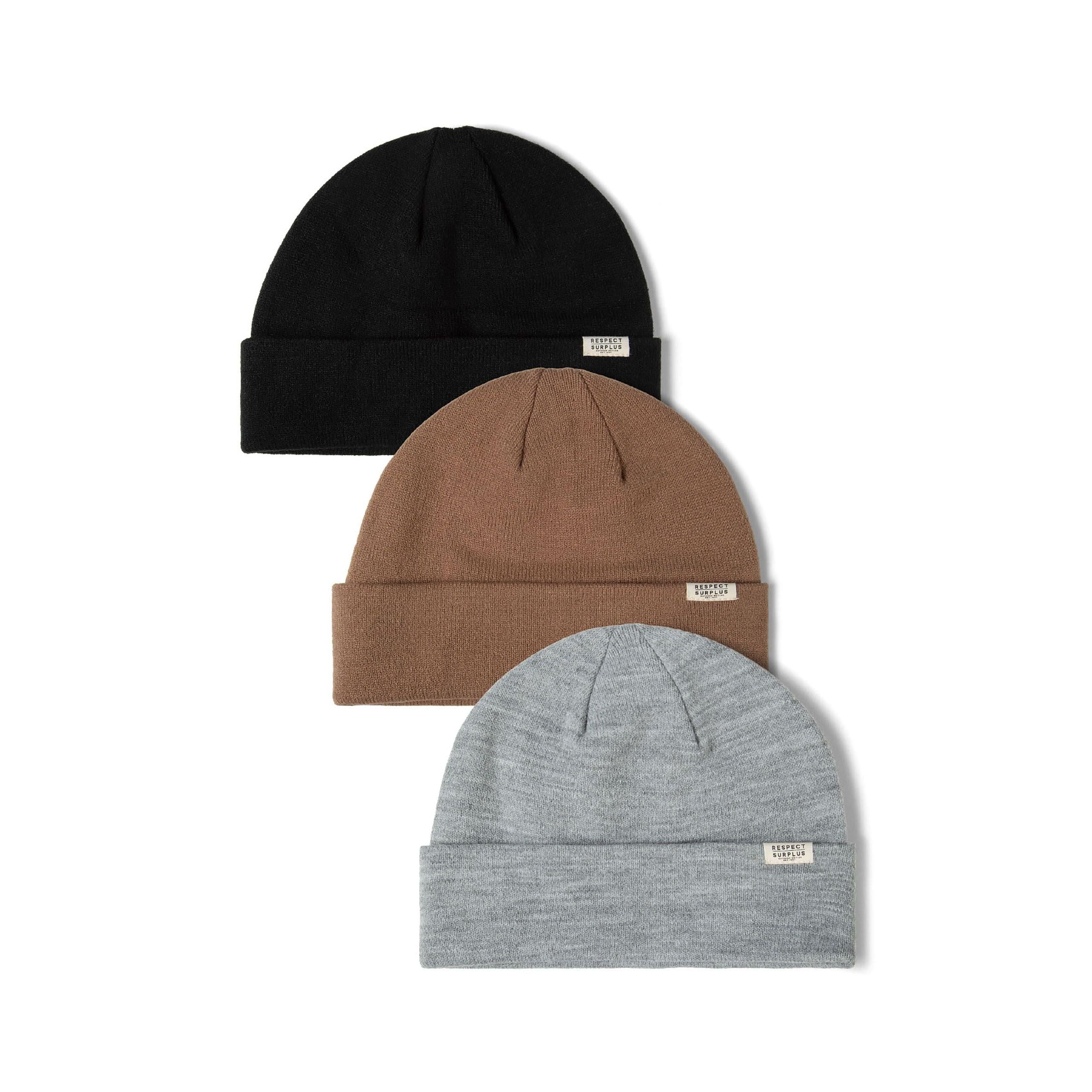 Three ribbed beanie hats arranged overlapping on white background showing black, brown and grey colours with fold-up cuffs and small white brand labels