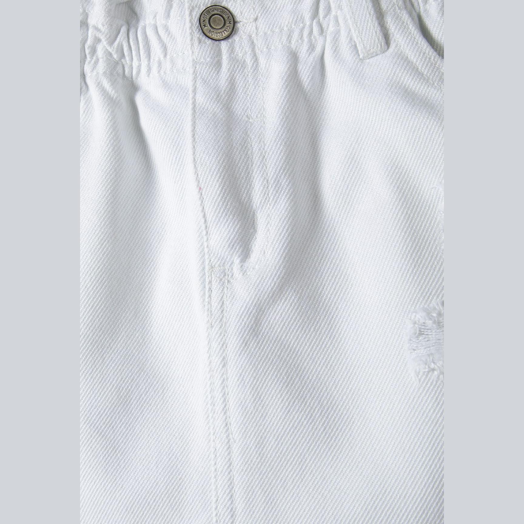 Close-up detail of white denim fabric texture with gathered paperbag waistband and metal button