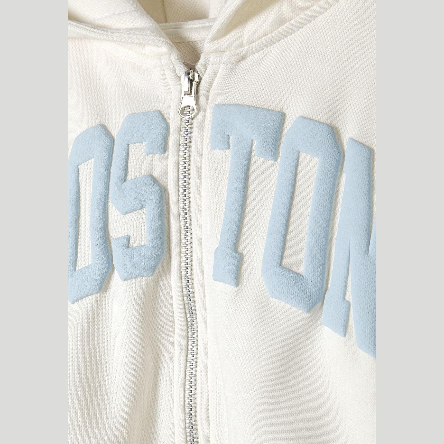 Close-up detail of cream joggers showing blue vintage-style text print reading 'USA 1967' with memories script text