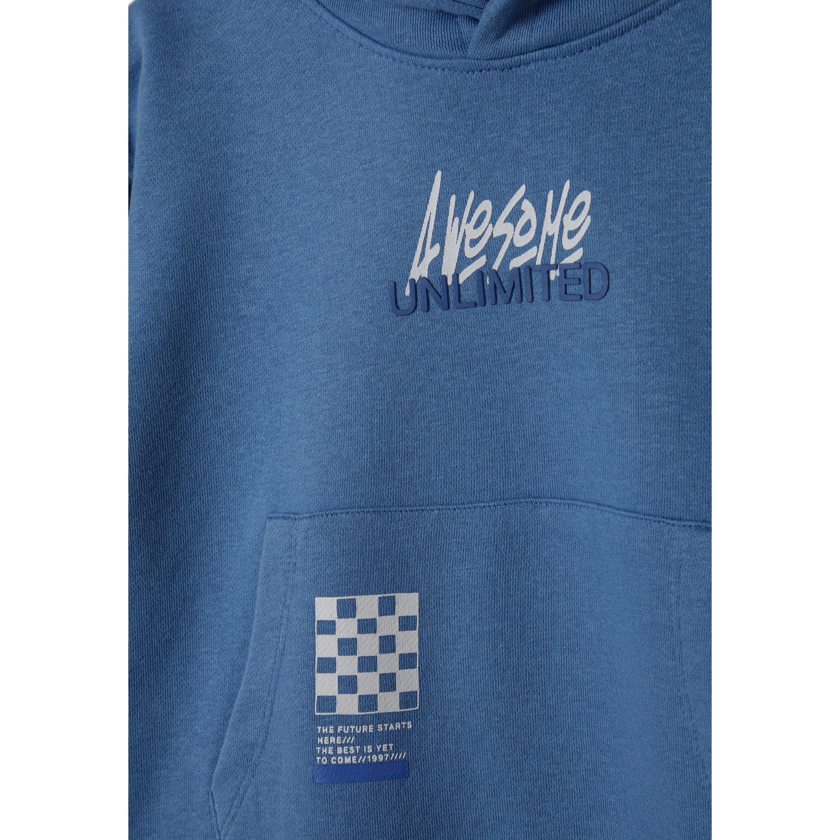 Close-up detail of blue joggers showing white 'Awesome Unlimited' text graphics on the leg