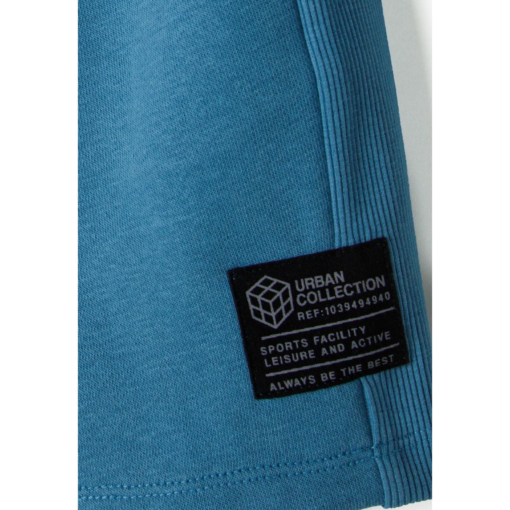 Close-up detail of blue fleece shorts showing ribbed side panel texture and Urban Collection label