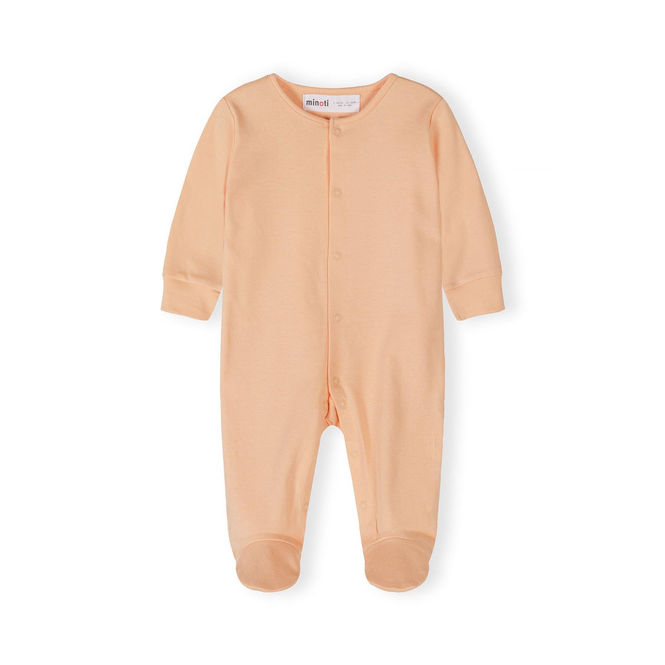 Close-up detail of cream sleepsuit showing Minoti label, snap button closures and ribbed neckline construction