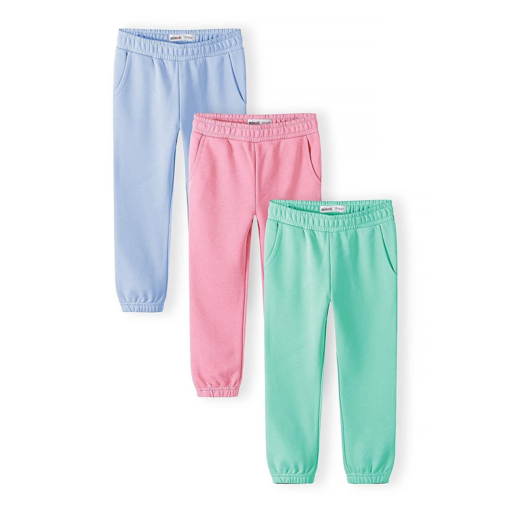 Three joggers laid flat showing coral pink, turquoise green and light blue colours with elasticated waistbands and side pockets on white background