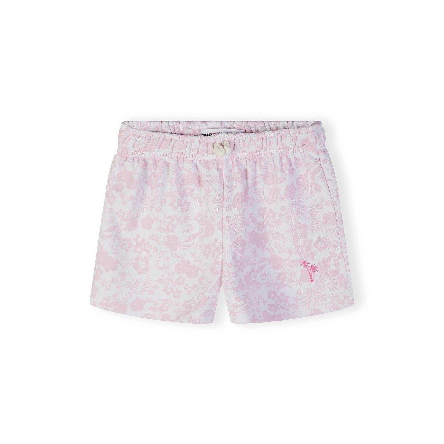 Close-up detail of tropical floral print pattern in pink and white with small pink palm tree embroidery visible on fabric