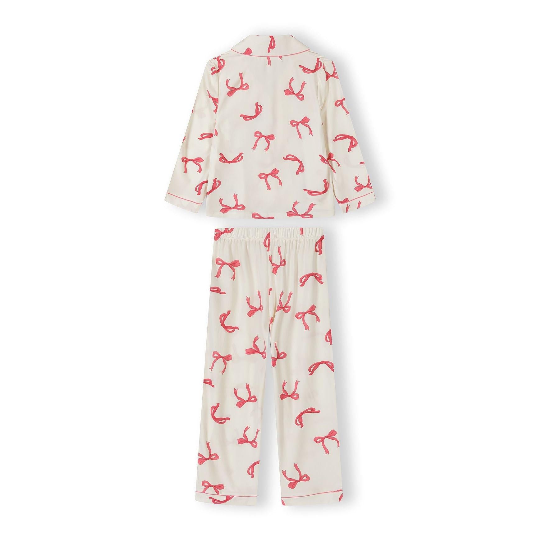Close-up view of pyjama top showing button-up front, notched collar and pink bow print pattern on cream fabric against white background
