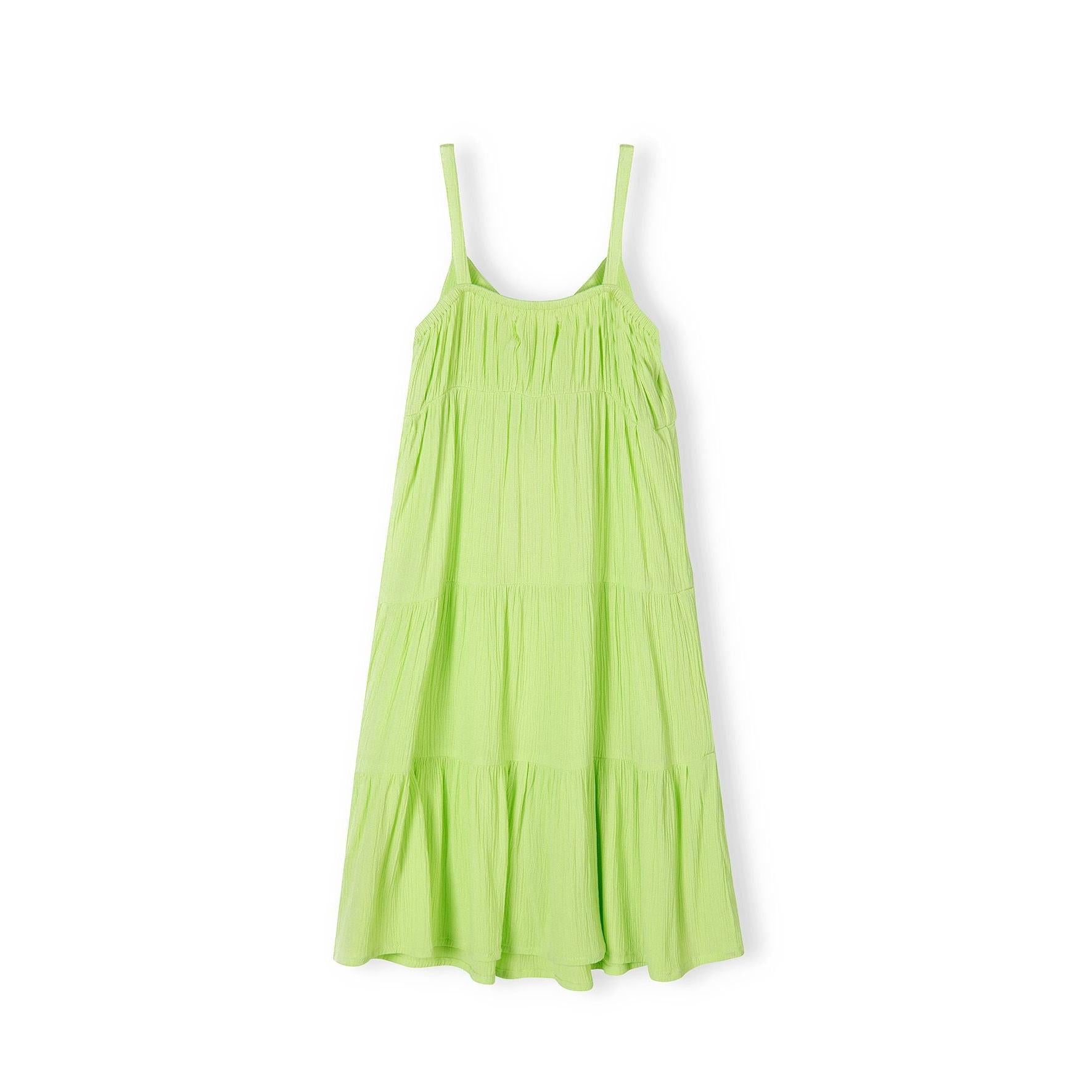 Bright green tiered strappy dress laid flat showing three-tier skirt design and adjustable shoulder straps on white background