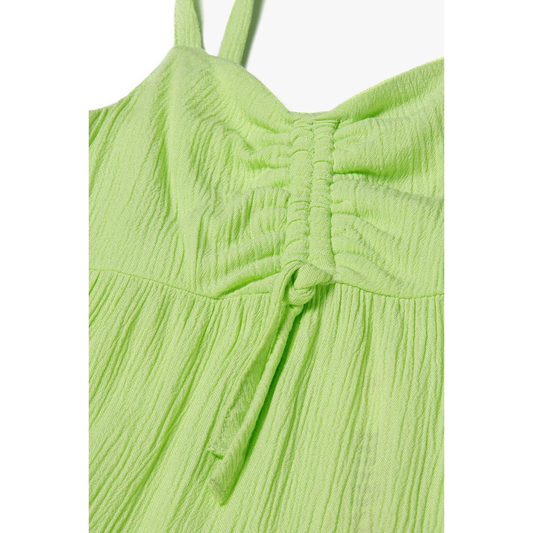 Close-up detail of bright green dress showing ruched chest panel with gathered fabric and adjustable shoulder straps