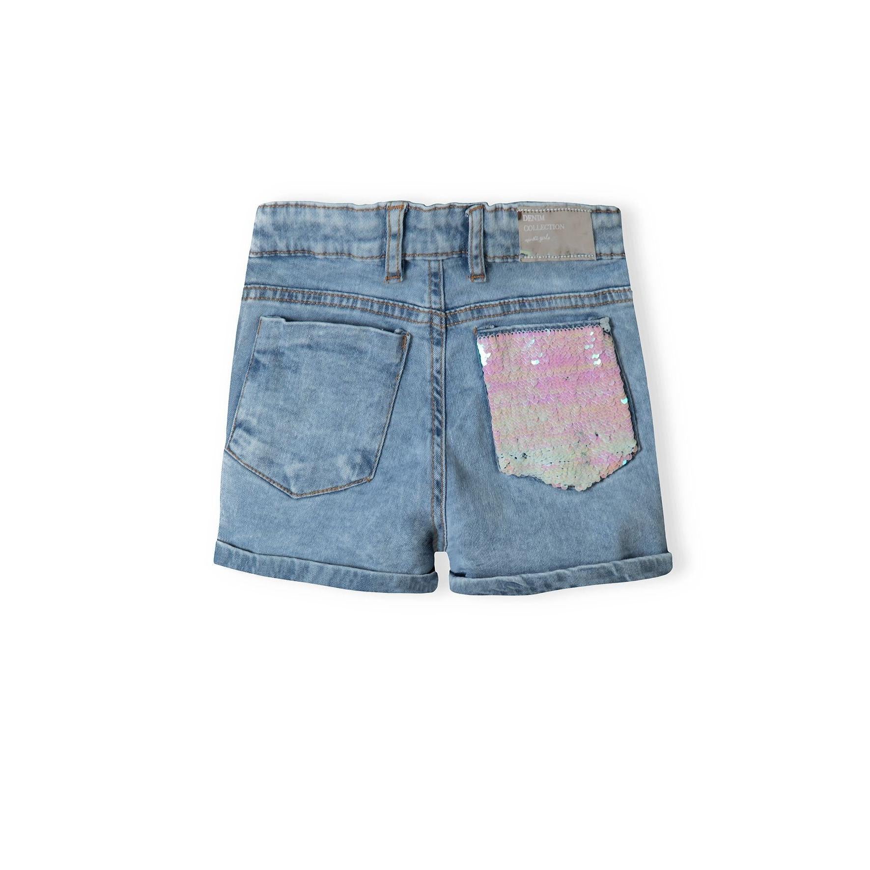 Close-up of back pocket with white sequin embellishment on light blue denim, showing turn-up hem detail and contrast stitching