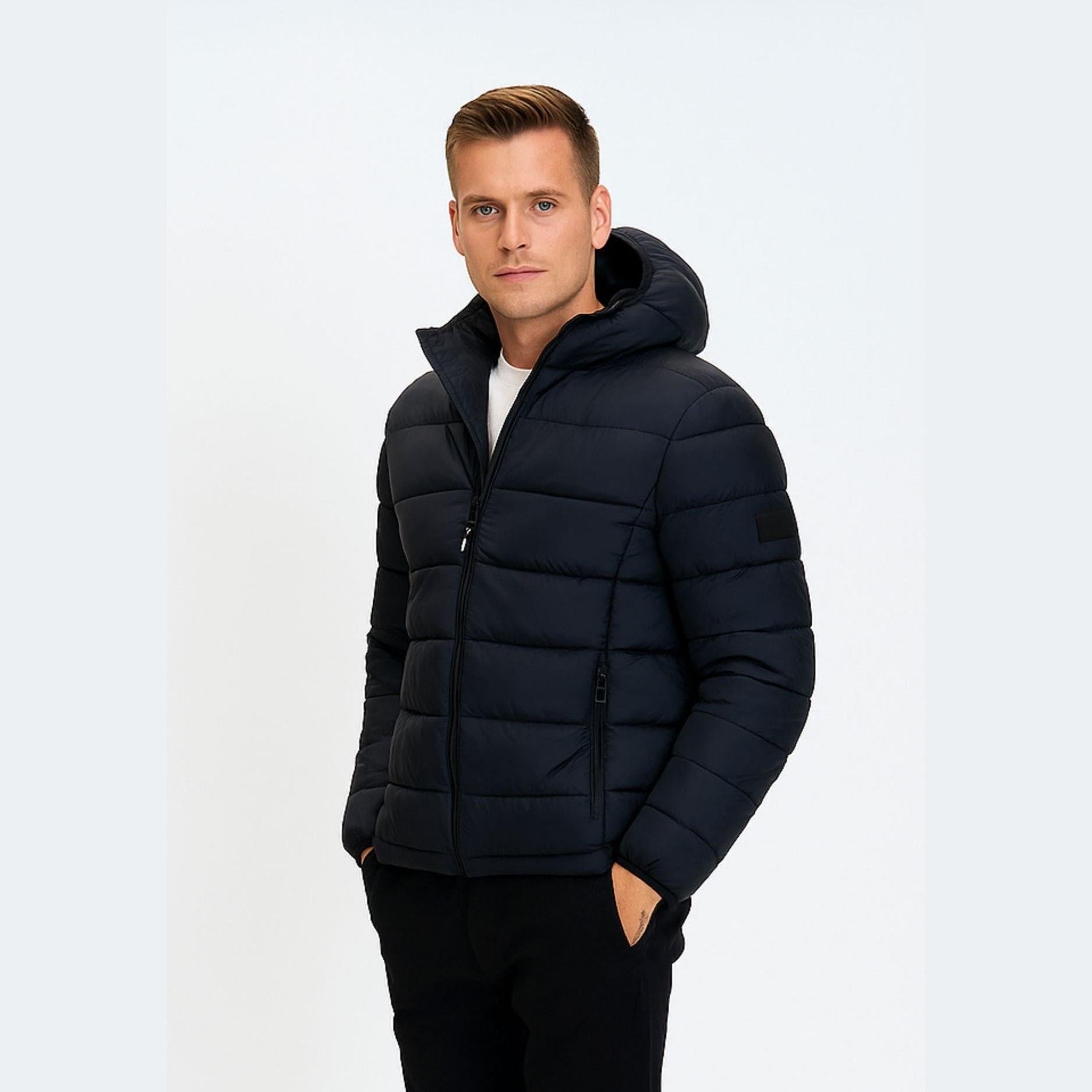 Man wearing navy blue padded jacket with hood on white background, front view showing quilted design and zip closure