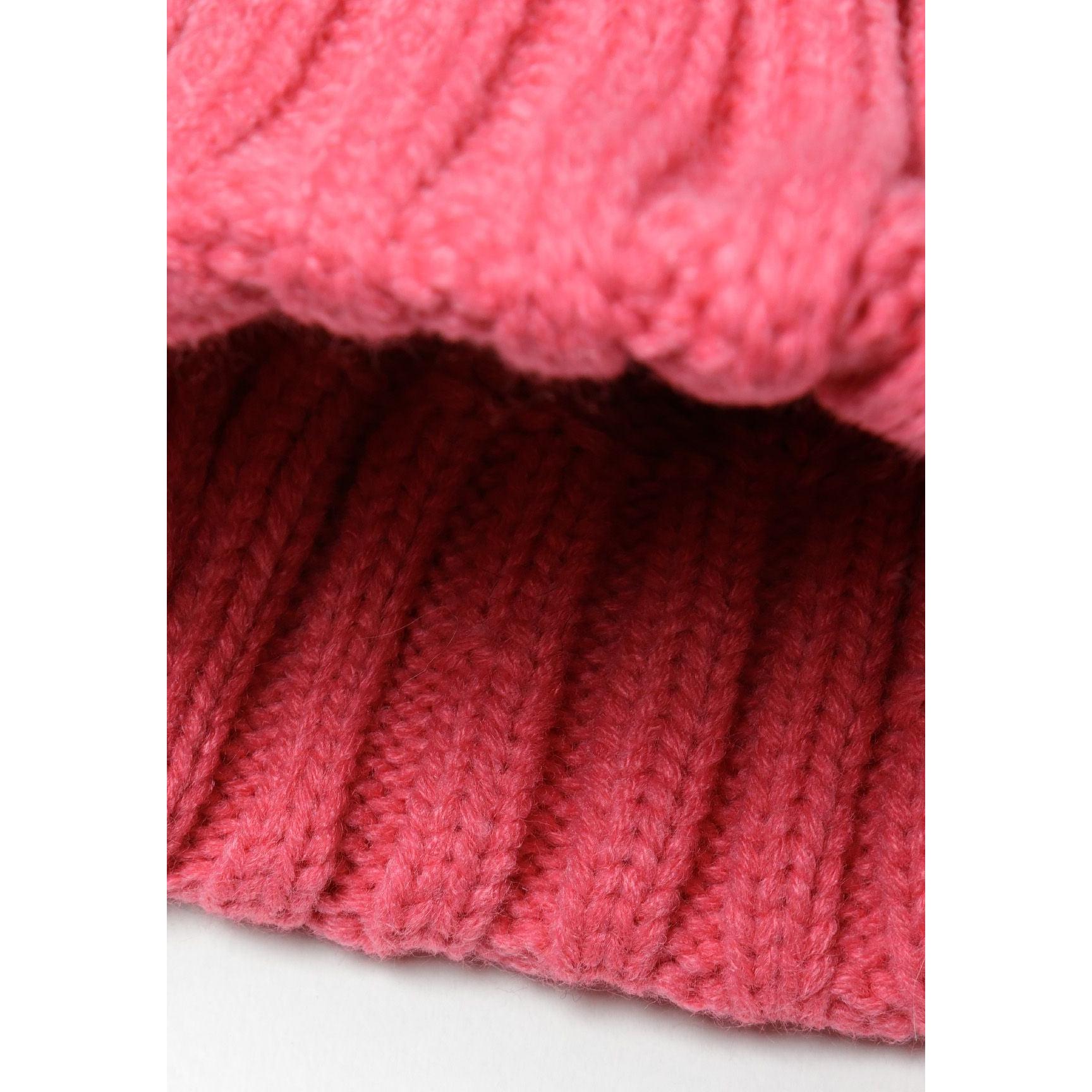 Detail view of ribbed cuff hem showing pink cable knit pattern and texture