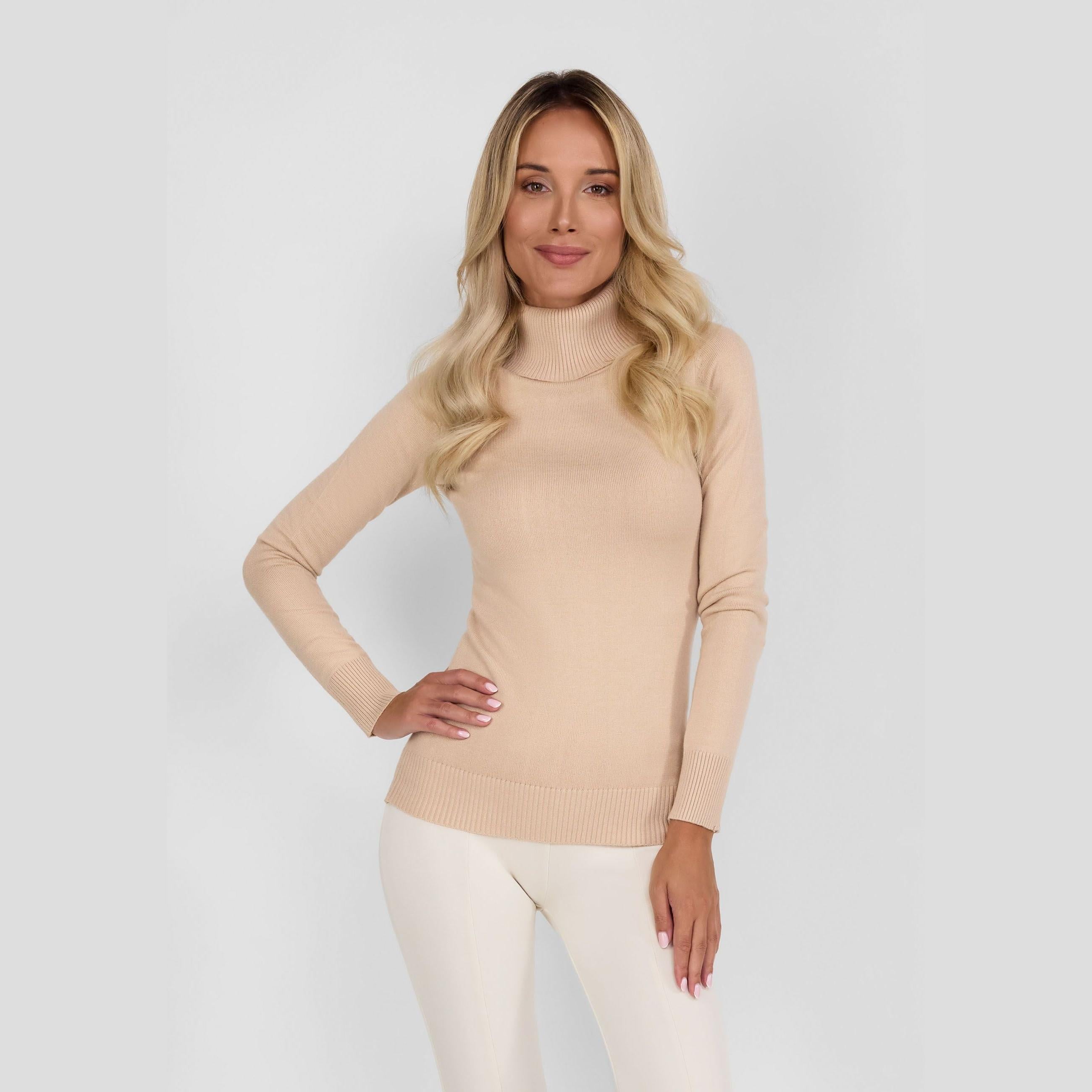 Woman wearing beige turtleneck jumper with cream trousers against white background, front view showing fitted silhouette and high collar
