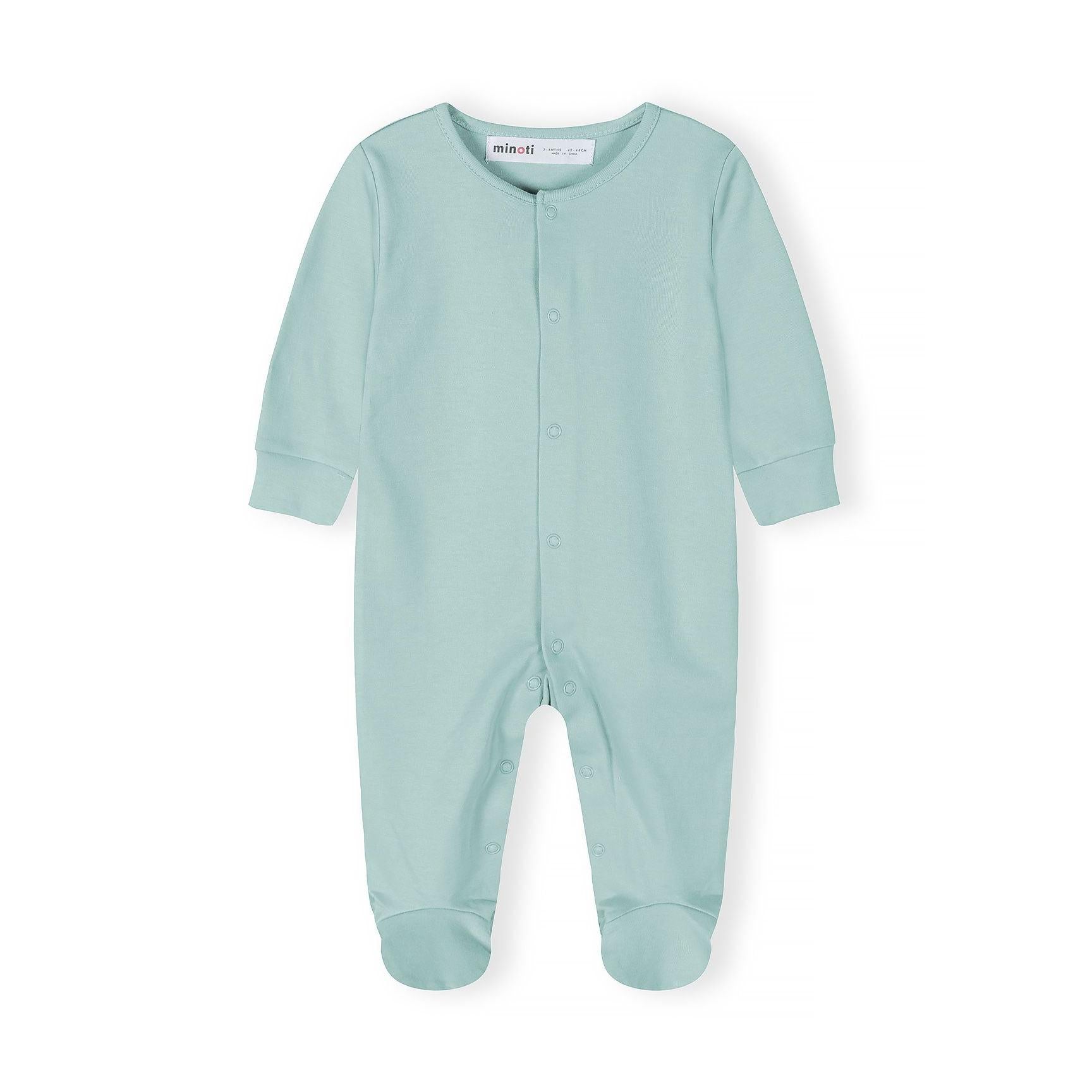 Close-up detail of mint green sleepsuit showing snap button fastenings and Minoti brand label at the neckline with soft jersey fabric texture visible