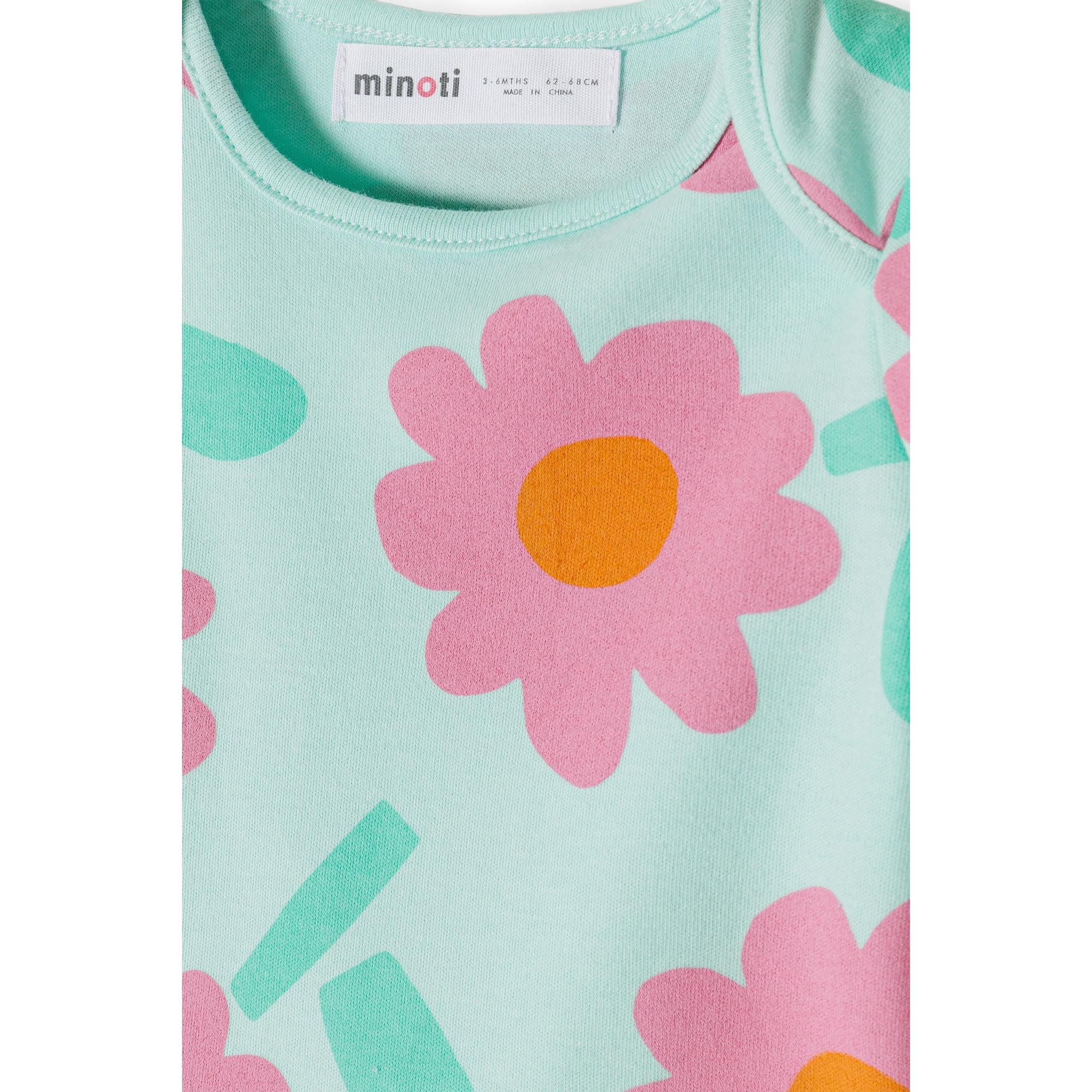 Close-up detail of mint bodysuit showing Minoti label, neckline construction and large pink daisy print with green leaves