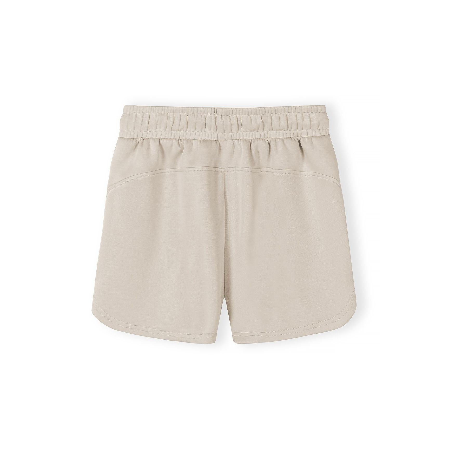 Close-up detail of beige shorts showing elasticated waistband with drawstring ties on neutral background