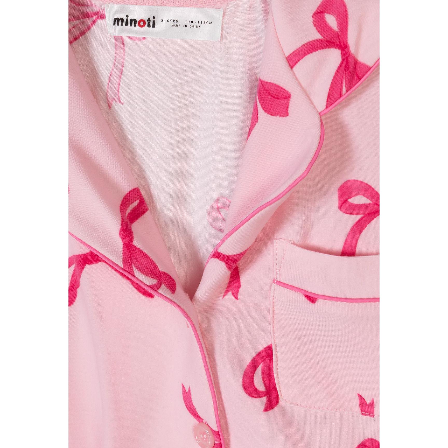 Close-up detail of pink pyjama top showing Minoti label, bow print pattern and button fastening