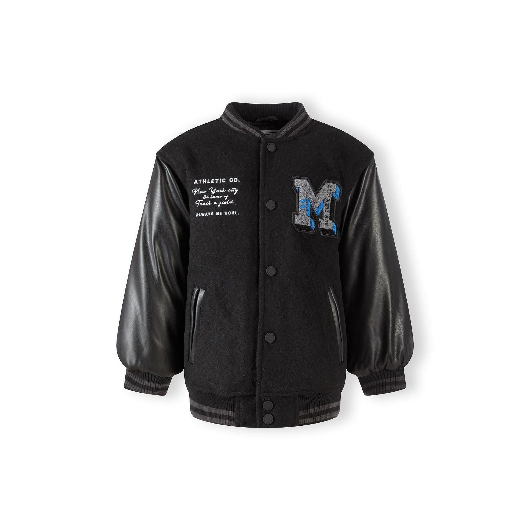 Black baseball jacket laid flat showing Minoti label, press stud fastening, and contrast between felt body and faux leather sleeves