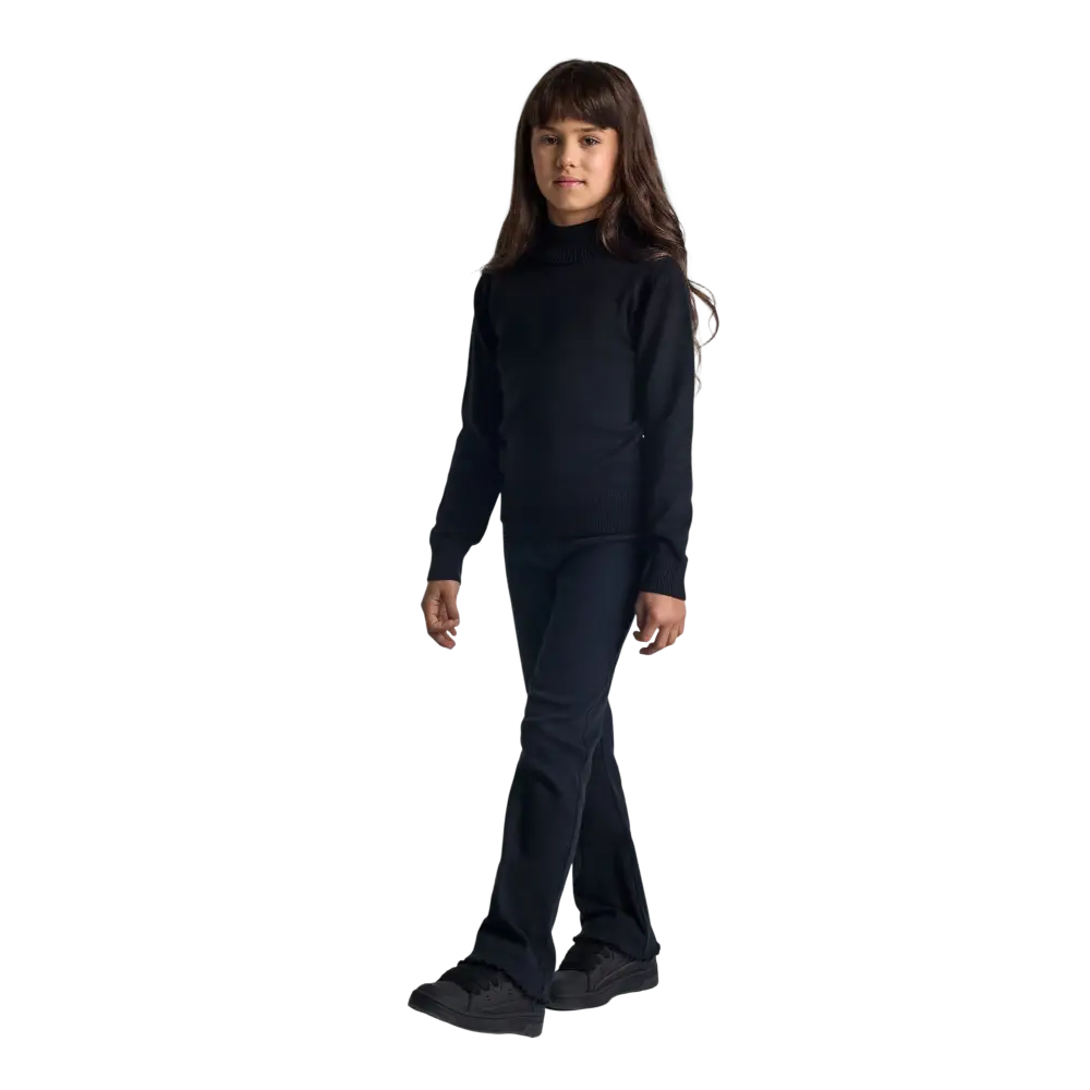 Young girl wearing black fine knit turtleneck jumper with long sleeves, standing against black background