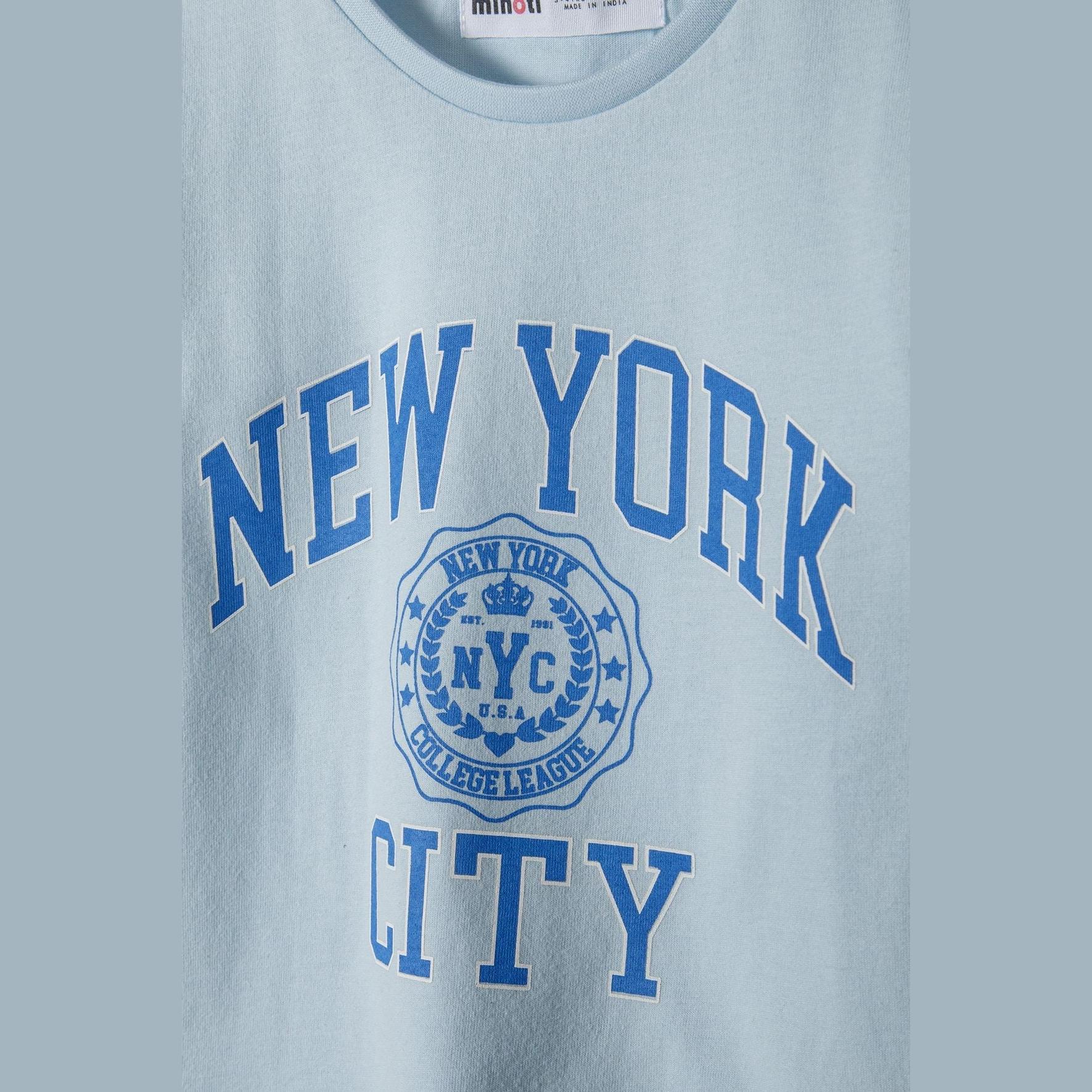 Close-up detail of New York City collegiate graphic print with NYC logo and college league text on light blue fabric