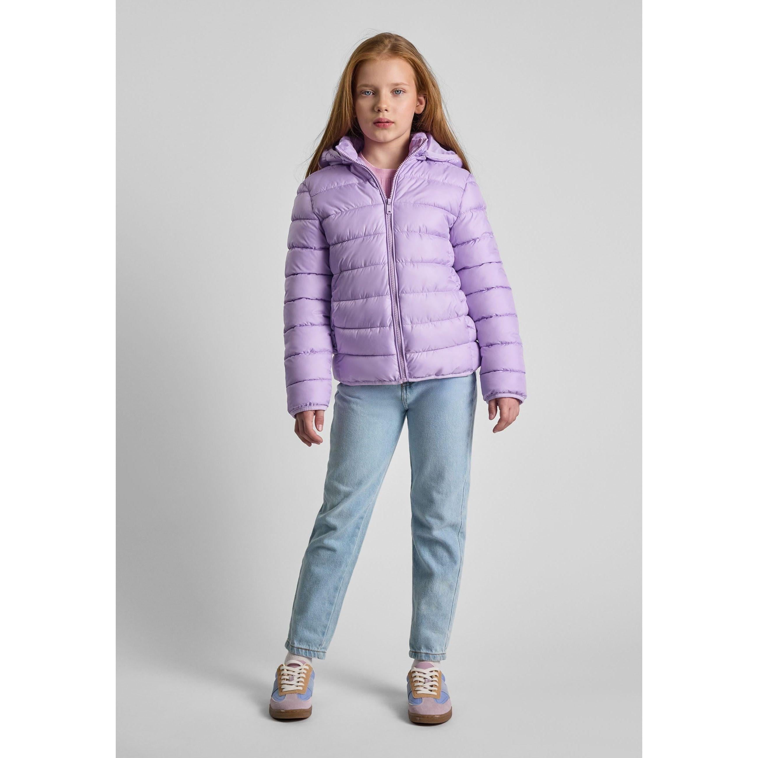 Girl wearing lilac quilted jacket with detachable hood, paired with light blue jeans and sneakers against white background