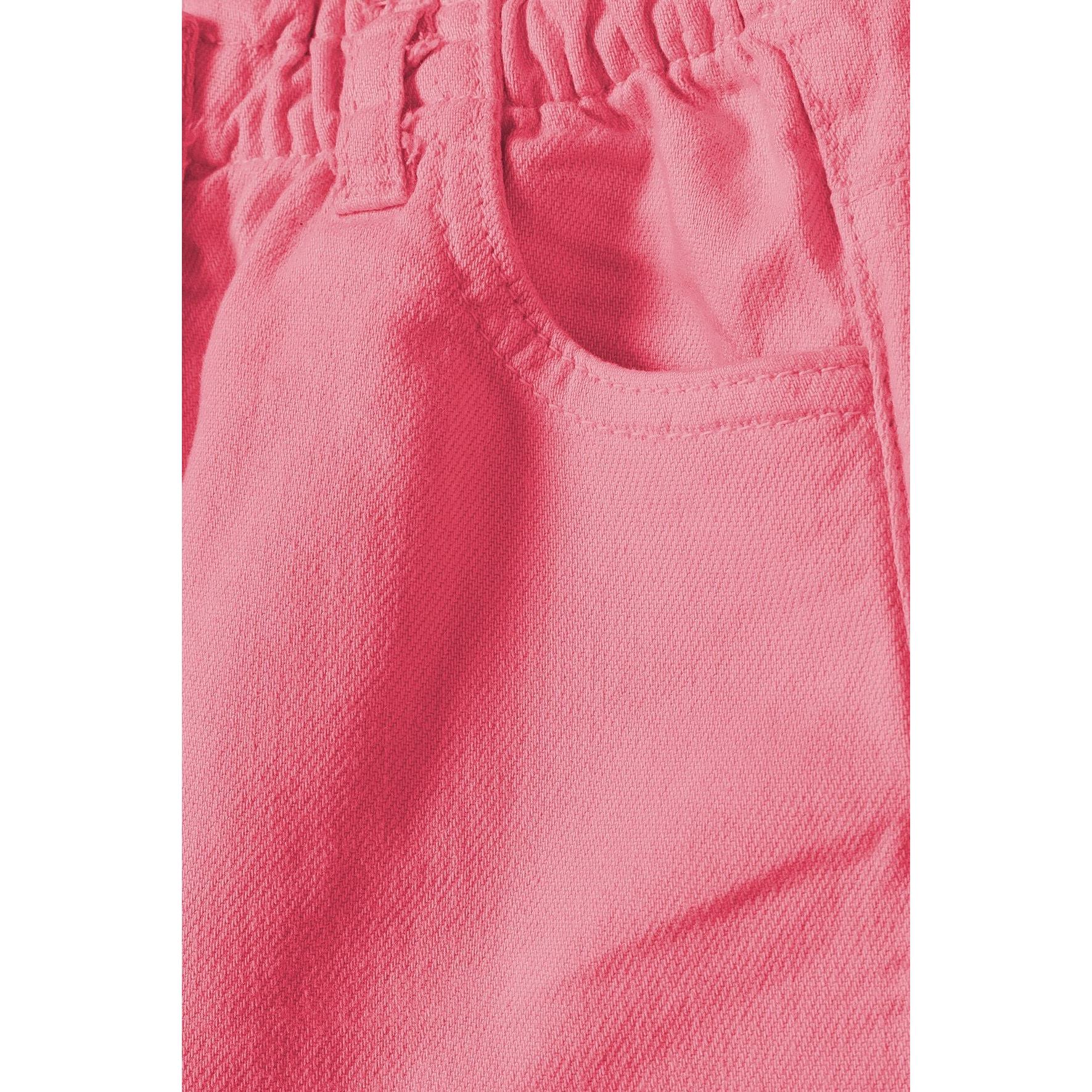 Close-up detail of coral pink twill fabric texture and front pocket construction